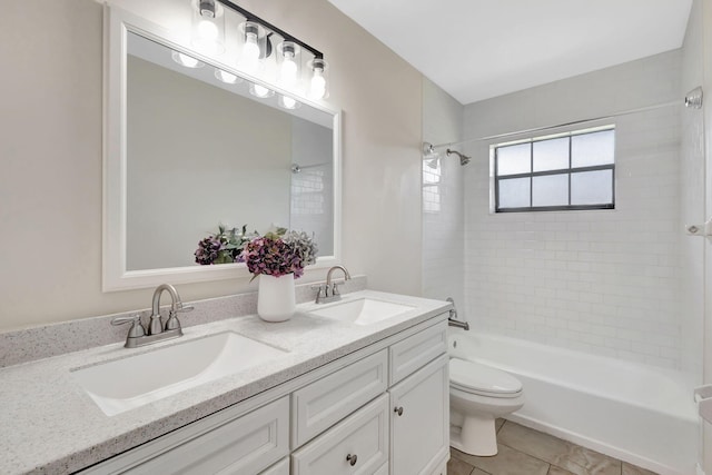 bathroom with double vanity, toilet, washtub / shower combination, and a sink