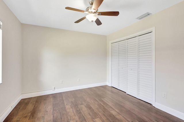 unfurnished bedroom with visible vents, baseboards, a closet, and wood finished floors