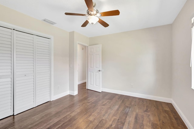 unfurnished bedroom featuring a ceiling fan, wood finished floors, baseboards, visible vents, and a closet