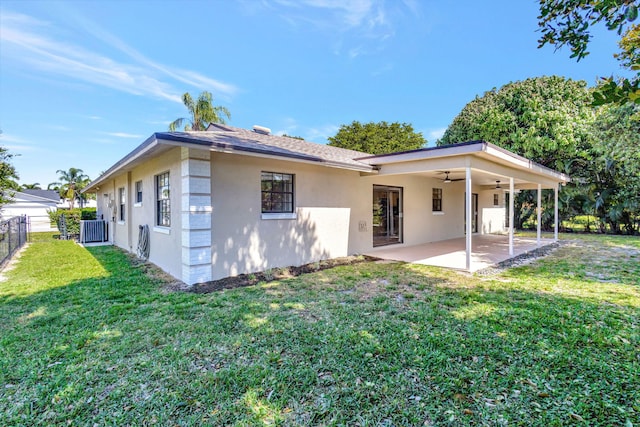 rear view of property featuring a ceiling fan, central AC unit, fence, stucco siding, and a patio area