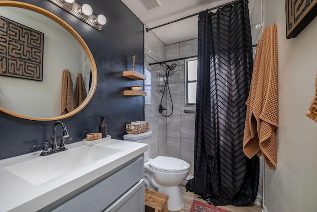 full bathroom with visible vents, toilet, vanity, and a tile shower