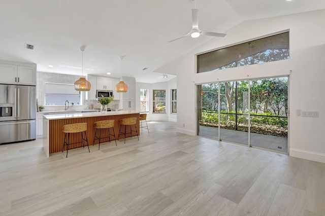 11287 Vivero Ave, Boynton Beach, FL 33437 - kitchen with visible vents, light countertops, a ceiling fan, a breakfast bar, and stainless steel appliances