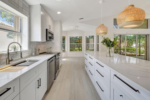 11287 Vivero Ave, Boynton Beach, FL 33437 - kitchen with pendant lighting, light wood-style floors, a sink, stainless steel appliances, and backsplash