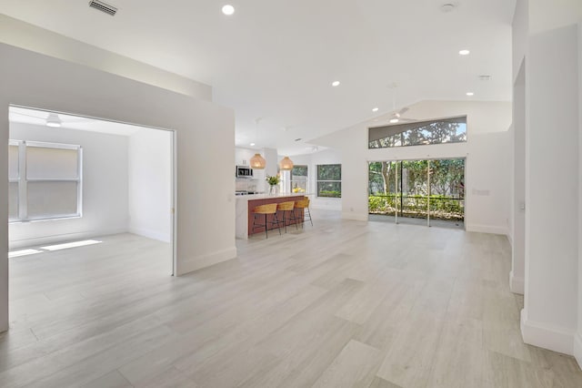 11287 Vivero Ave, Boynton Beach, FL 33437 - unfurnished living room with light wood-style floors, recessed lighting, visible vents, and lofted ceiling