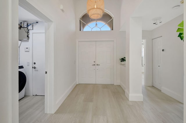 11287 Vivero Ave, Boynton Beach, FL 33437 - foyer entrance featuring light wood-style floors, baseboards, and washer / dryer