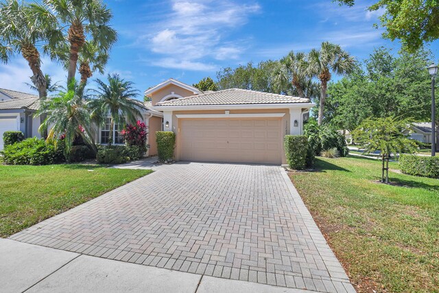 11287 Vivero Ave, Boynton Beach, FL 33437 - view of front of house featuring a tiled roof, an attached garage, a front lawn, and stucco siding