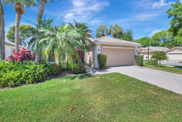 11287 Vivero Ave, Boynton Beach, FL 33437 - view of front of house with stucco siding, decorative driveway, a front lawn, a tile roof, and a garage