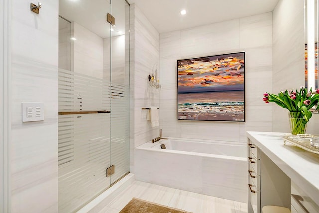 bathroom featuring vanity, a shower stall, a bath, and tile walls