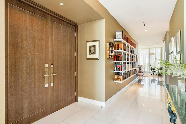 hallway with tile patterned floors, baseboards, and recessed lighting