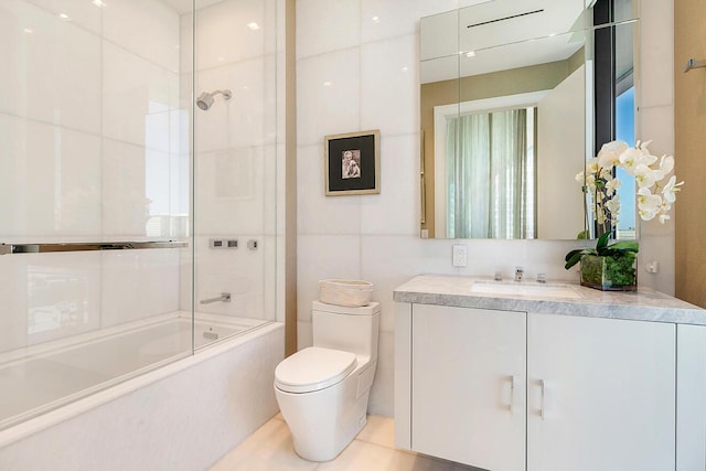 full bathroom featuring vanity, tile walls, toilet, and tub / shower combination