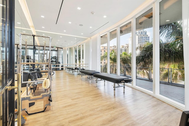 exercise room with a view of city, wood finished floors, and floor to ceiling windows