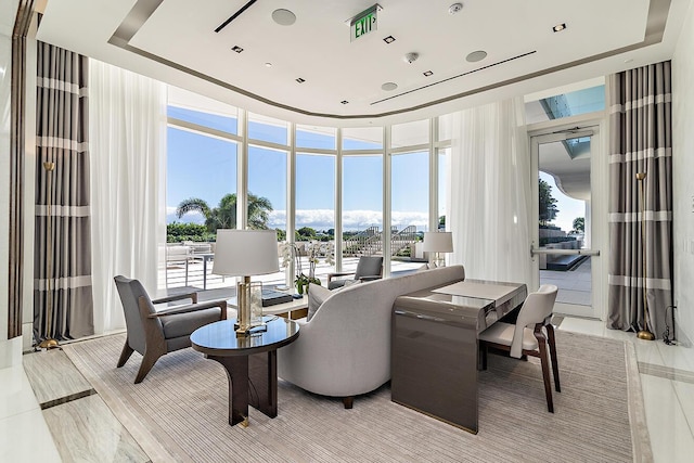 dining space featuring a wall of windows and a tray ceiling