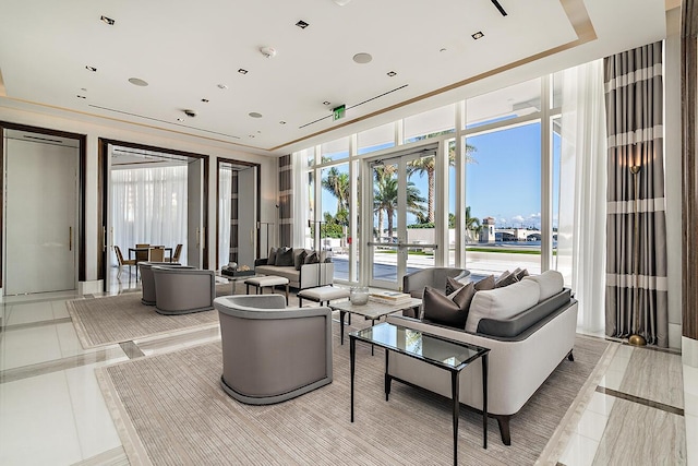 living area featuring a raised ceiling, floor to ceiling windows, and french doors