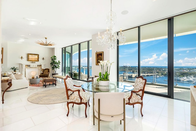 dining space with a water view, a notable chandelier, floor to ceiling windows, and tile patterned flooring