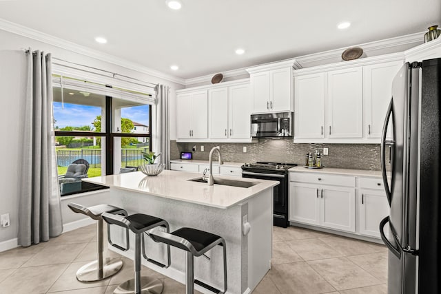 kitchen with backsplash, black range with electric stovetop, freestanding refrigerator, and a sink