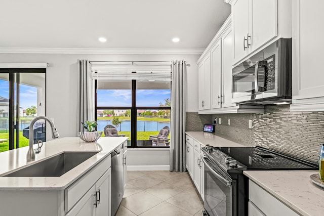 kitchen featuring a healthy amount of sunlight, ornamental molding, a sink, appliances with stainless steel finishes, and backsplash