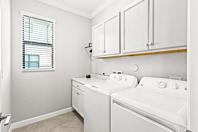 laundry room featuring crown molding, baseboards, washing machine and dryer, light tile patterned floors, and cabinet space