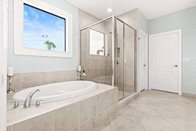 full bathroom featuring a garden tub, a stall shower, and tile patterned flooring