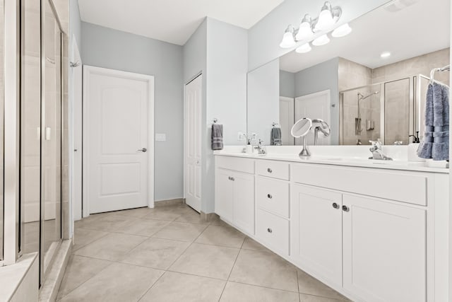 bathroom with tile patterned flooring, visible vents, a shower stall, double vanity, and a sink