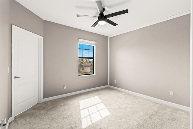 carpeted empty room with baseboards and a ceiling fan