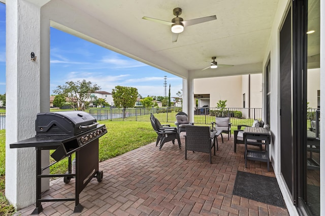 view of patio with grilling area, an outdoor hangout area, a ceiling fan, and fence