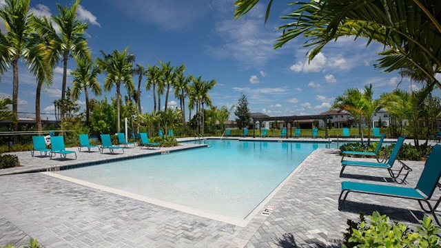 community pool with a patio and fence