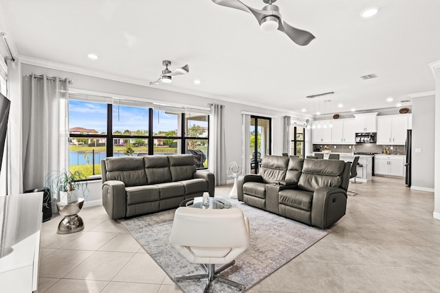 living area with light tile patterned floors, ceiling fan, and crown molding