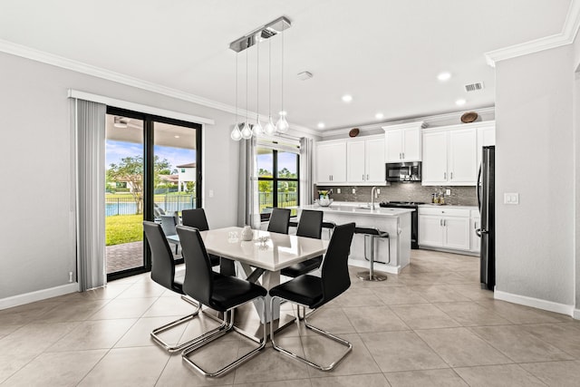 dining space with light tile patterned floors, visible vents, crown molding, and baseboards