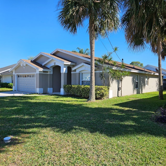 view of front of house featuring stucco siding, a front yard, and an attached garage