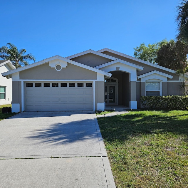 view of front of home with stucco siding, concrete driveway, and an attached garage