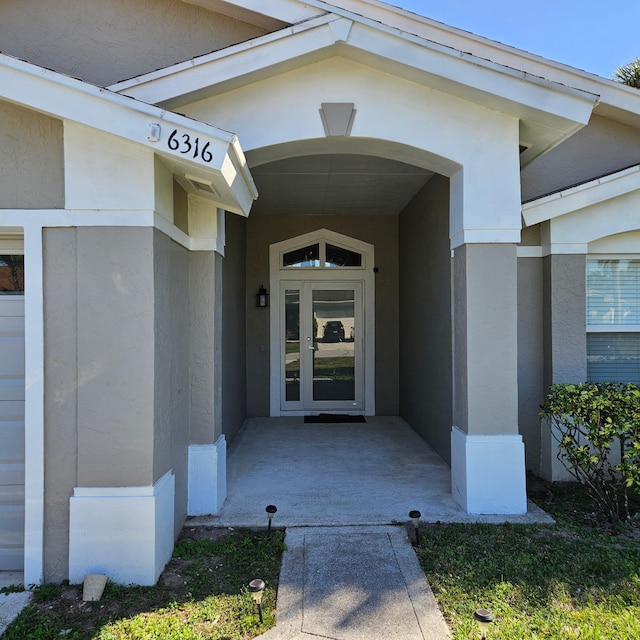 view of exterior entry with stucco siding