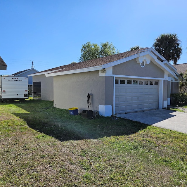 view of side of home featuring concrete driveway, a yard, a garage, and stucco siding