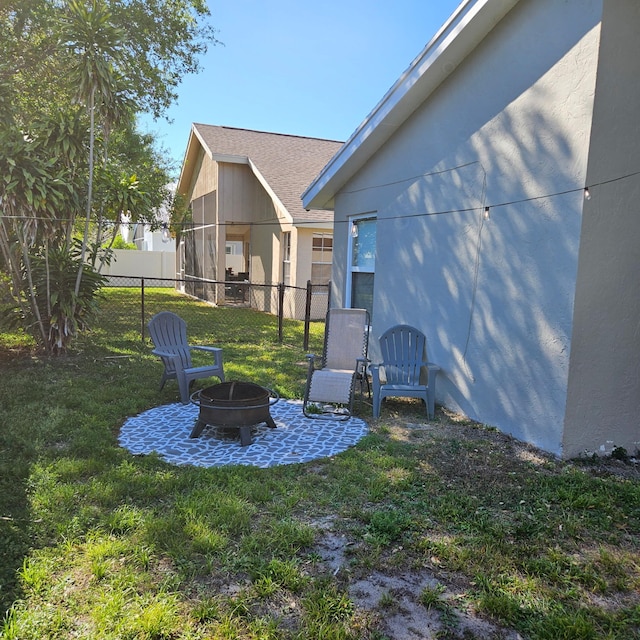 view of yard featuring a patio area, a fire pit, and fence