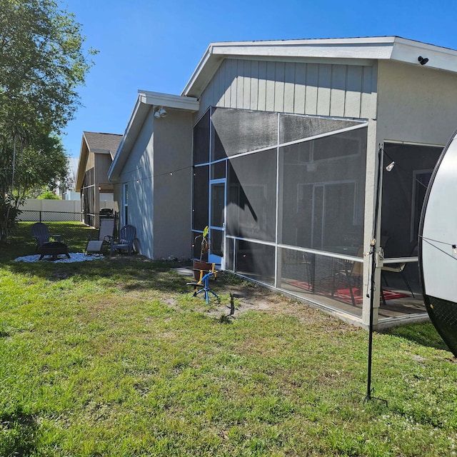 view of side of property featuring a lawn and fence