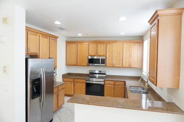 kitchen featuring light tile patterned floors, recessed lighting, a peninsula, stainless steel appliances, and a sink