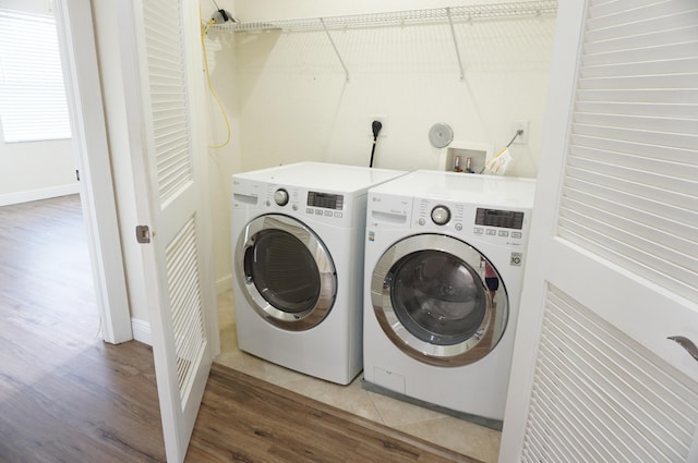 laundry room with separate washer and dryer, wood finished floors, and laundry area