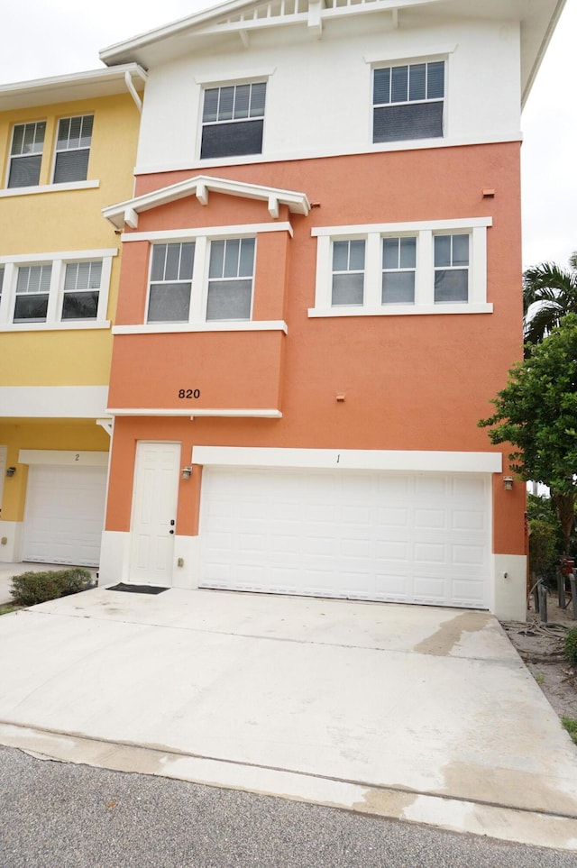 view of property featuring stucco siding, an attached garage, and concrete driveway