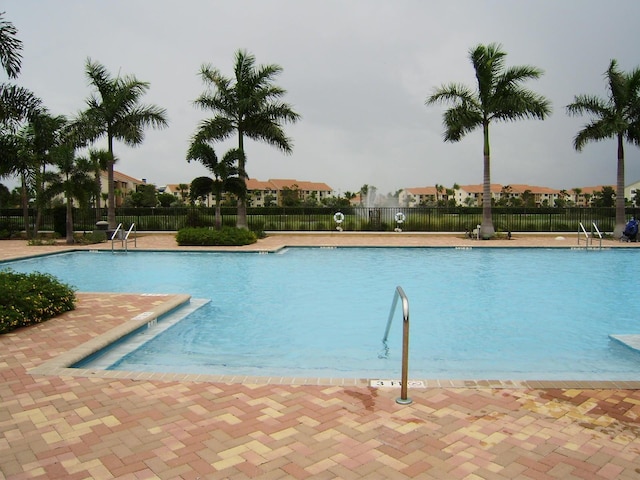 pool with a patio and fence