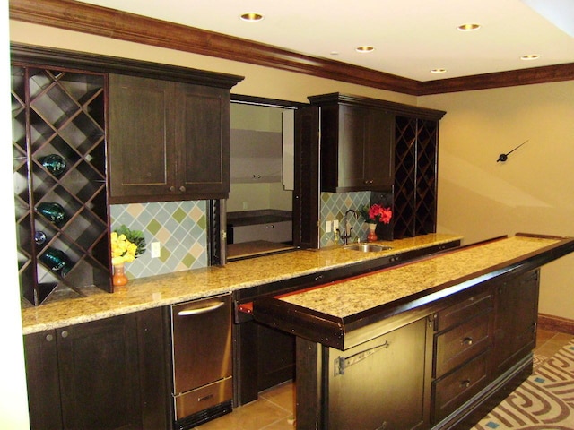 bar featuring baseboards, wet bar, ornamental molding, a sink, and backsplash