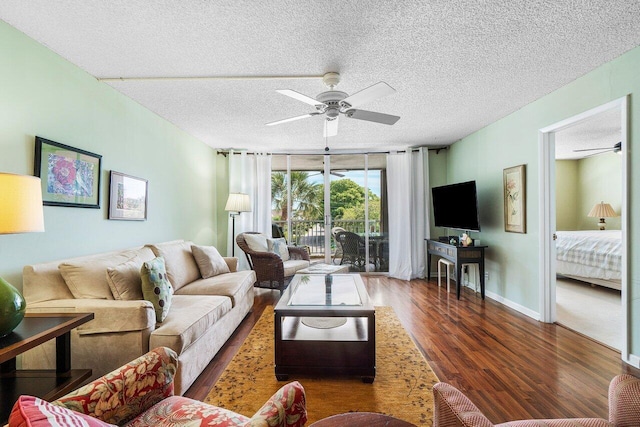 living room featuring baseboards, wood finished floors, a textured ceiling, and ceiling fan