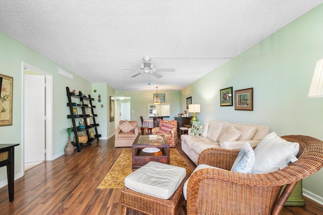 living area with visible vents, baseboards, wood finished floors, a textured ceiling, and a ceiling fan