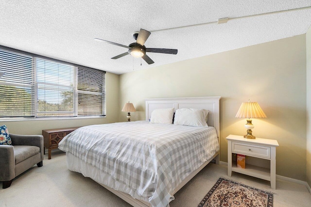 bedroom featuring baseboards, a textured ceiling, ceiling fan, and carpet flooring