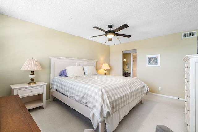 bedroom with visible vents, a textured ceiling, baseboards, light colored carpet, and ceiling fan