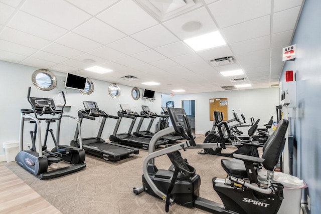 gym featuring baseboards, visible vents, and a drop ceiling