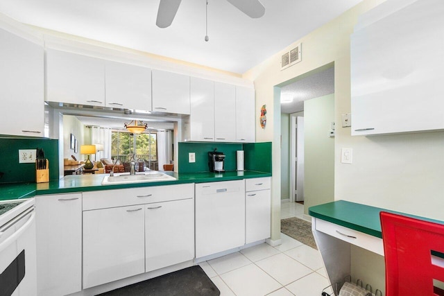 kitchen with visible vents, white dishwasher, a sink, stove, and white cabinets