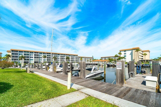 view of dock featuring a lawn and a water view