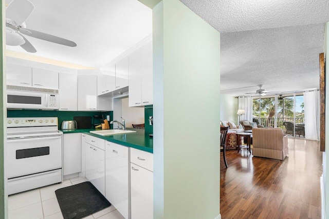 kitchen featuring white cabinetry, ceiling fan, white appliances, a textured ceiling, and a sink