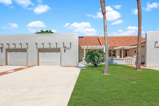 view of front of house with stucco siding, driveway, a front yard, and an attached garage