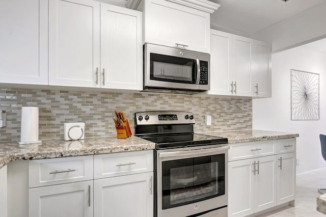 kitchen featuring white cabinetry, light stone counters, tasteful backsplash, and stainless steel appliances