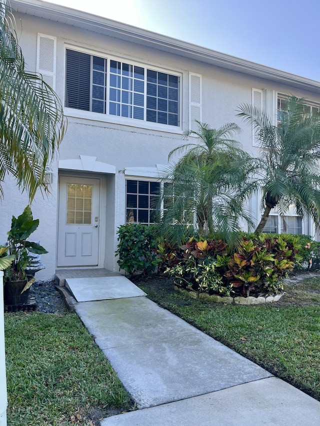 doorway to property featuring stucco siding